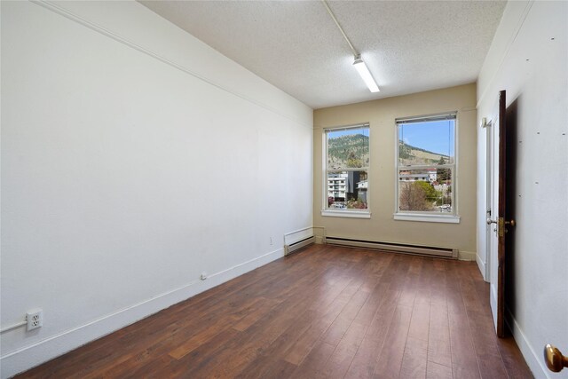 21 N Last Chance Gulch Gulch Unit 3L, Helena, MT 59601 - unfurnished room featuring a baseboard radiator, dark wood-style flooring, a textured ceiling, and baseboards