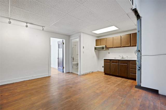 21 N Last Chance Gulch Gulch Unit 3L, Helena, MT 59601 - kitchen with light countertops, wood finished floors, stainless steel microwave, baseboards, and a drop ceiling
