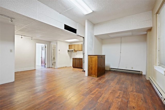 21 N Last Chance Gulch Gulch Unit 3L, Helena, MT 59601 - unfurnished living room with a baseboard radiator, a paneled ceiling, hardwood / wood-style flooring, and track lighting