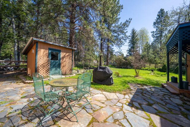 102 Scenery Rd, Libby, MT 59923 - view of patio featuring grilling area, an outbuilding, a shed, and outdoor dining area