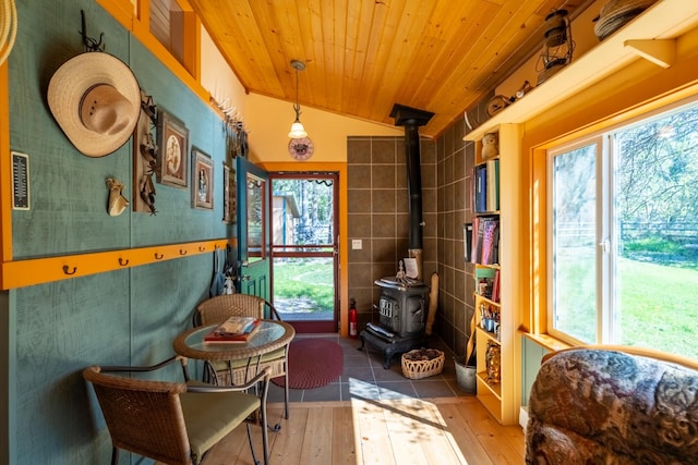 102 Scenery Rd, Libby, MT 59923 - living area featuring a wood stove, wood-type flooring, vaulted ceiling, wooden ceiling, and tile walls