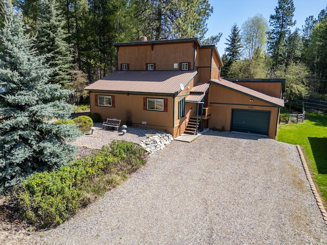 102 Scenery Rd, Libby, MT 59923 - view of front of home with driveway, an attached garage, metal roof, and fence