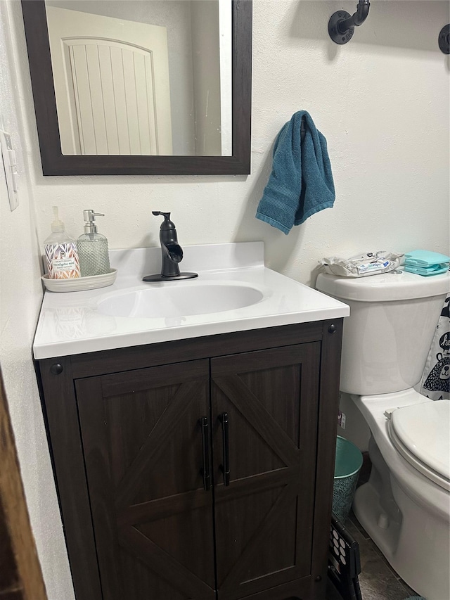 half bath featuring vanity and toilet