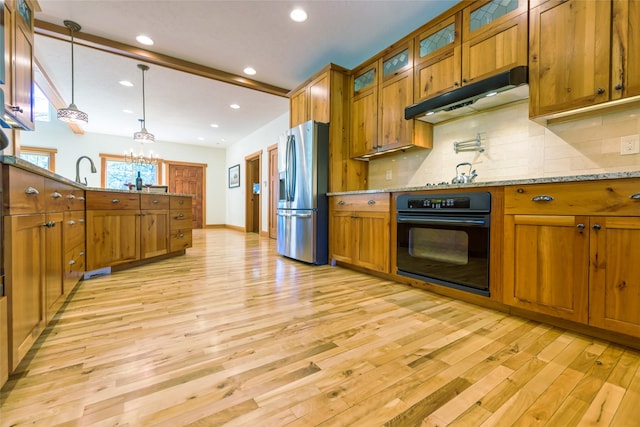 10758 Sleeman Creek Rd, Lolo, MT 59847 - kitchen with black oven, stainless steel refrigerator with ice dispenser, under cabinet range hood, brown cabinets, and recessed lighting