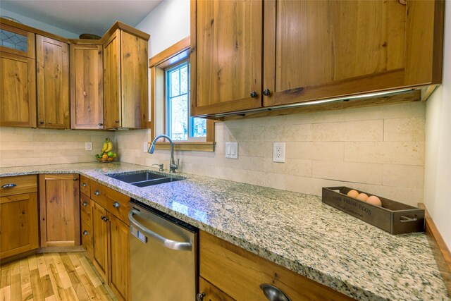 10758 Sleeman Creek Rd, Lolo, MT 59847 - kitchen with dishwasher, a sink, brown cabinetry, and tasteful backsplash