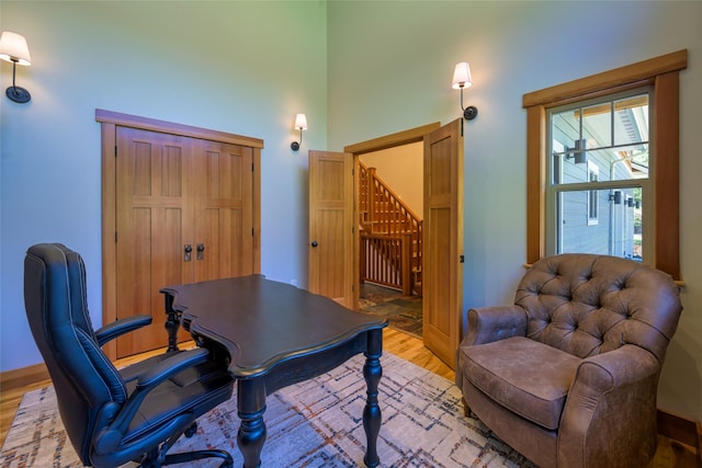 10758 Sleeman Creek Rd, Lolo, MT 59847 - office space featuring light wood-style flooring, a towering ceiling, and baseboards