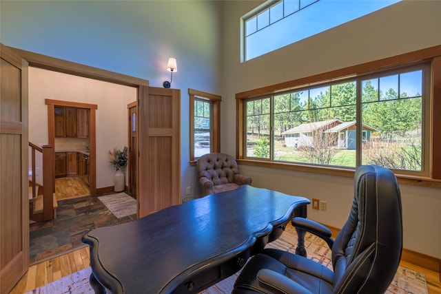 10758 Sleeman Creek Rd, Lolo, MT 59847 - office area with wood finished floors, a high ceiling, and baseboards
