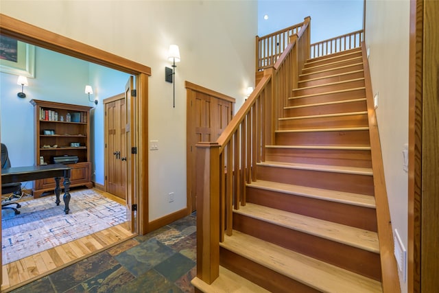 10758 Sleeman Creek Rd, Lolo, MT 59847 - stairs featuring stone finish floors, a towering ceiling, and baseboards