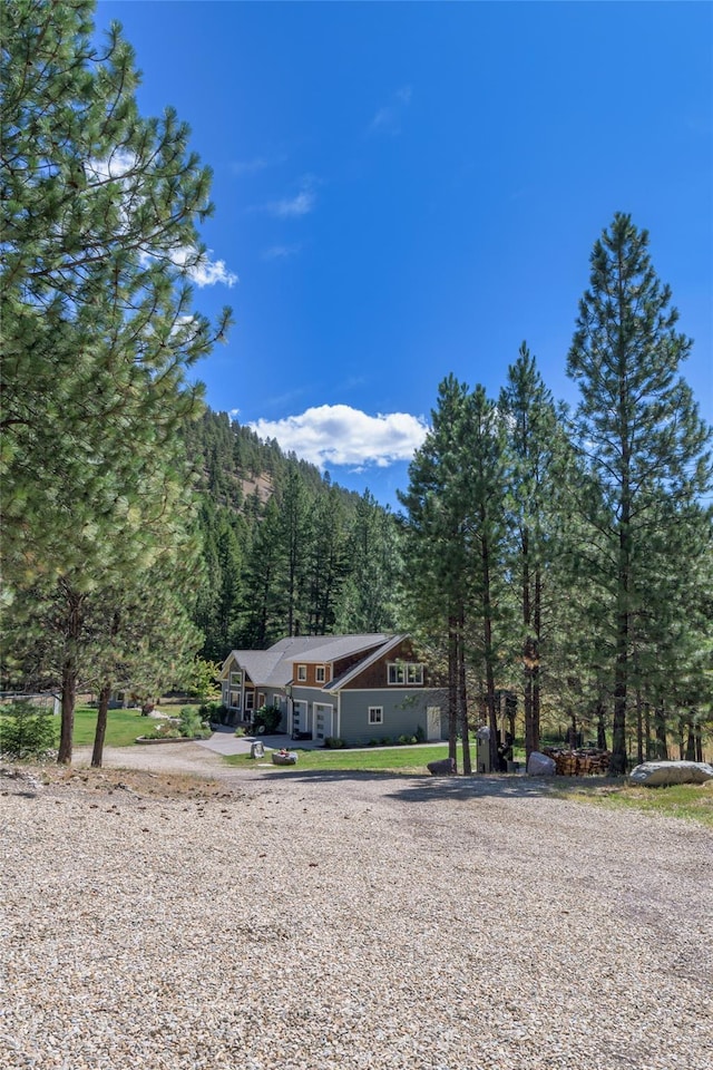 10758 Sleeman Creek Rd, Lolo, MT 59847 - view of front facade featuring a wooded view and driveway