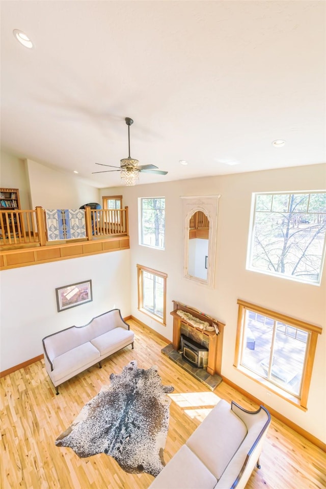 10758 Sleeman Creek Rd, Lolo, MT 59847 - living room with wood finished floors, a wood stove, recessed lighting, a ceiling fan, and baseboards