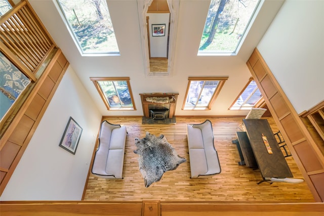 10758 Sleeman Creek Rd, Lolo, MT 59847 - living area featuring a towering ceiling, a skylight, healthy amount of natural light, and wood finished floors