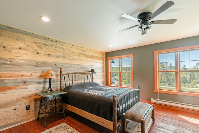 668 Dry Gulch Rd, Stevensville, MT 59870 - bedroom with wooden walls, baseboard heating, wood-type flooring, recessed lighting, and ceiling fan