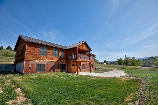 668 Dry Gulch Rd, Stevensville, MT 59870 - rear view of house with a yard, a standing seam roof, metal roof, and a balcony