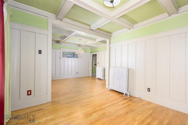 843 Lewisohn St, Butte, MT 59701 - spare room featuring a chandelier, coffered ceiling, radiator, a decorative wall, and beam ceiling