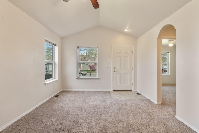 550 Green Tree Dr, Belgrade, MT 59714 - empty room featuring a ceiling fan, light colored carpet, arched walkways, vaulted ceiling, and baseboards