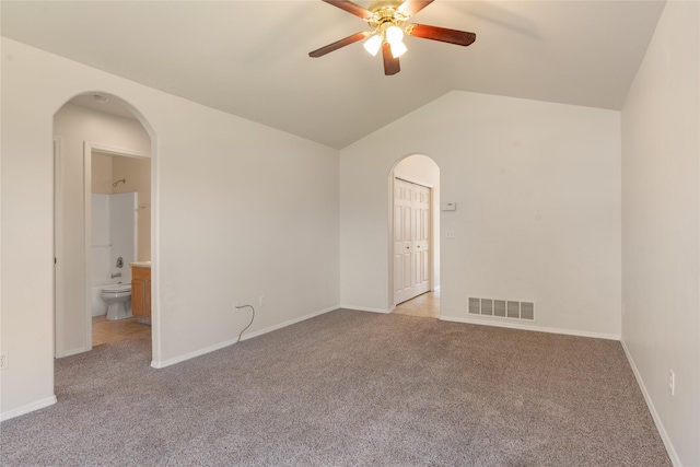 550 Green Tree Dr, Belgrade, MT 59714 - spare room featuring a ceiling fan, carpet flooring, arched walkways, vaulted ceiling, and baseboards