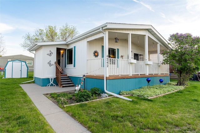 4242 Morningside Cir, Great Falls, MT 59405 - manufactured / mobile home featuring a porch, a storage shed, a front yard, and an outdoor structure