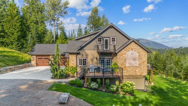 15 Sandi Ln, Heron, MT 59844 - view of front facade featuring a balcony, stone siding, an attached garage, and a front yard