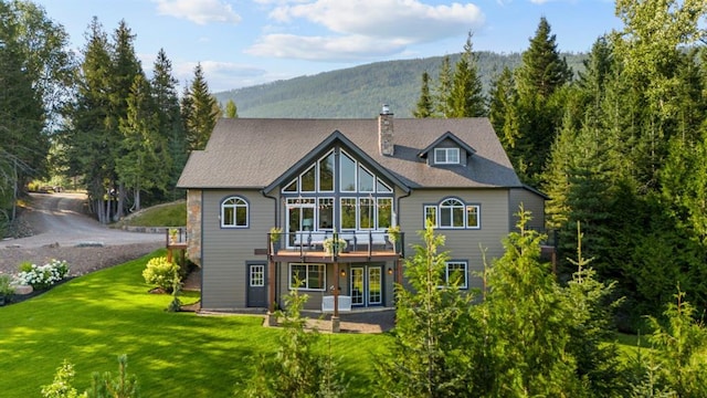 15 Sandi Ln, Heron, MT 59844 - rear view of property featuring a chimney, a lawn, and a deck with mountain view