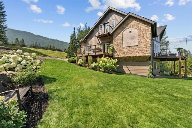 15 Sandi Ln, Heron, MT 59844 - view of property exterior featuring a balcony, stone siding, a lawn, and a mountain view