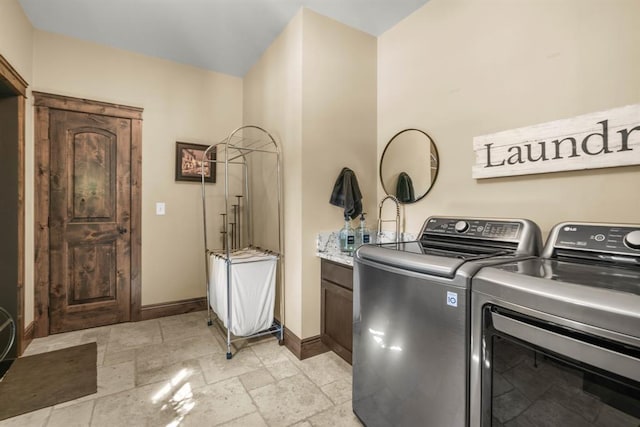 15 Sandi Ln, Heron, MT 59844 - clothes washing area featuring baseboards, cabinet space, separate washer and dryer, and stone tile flooring