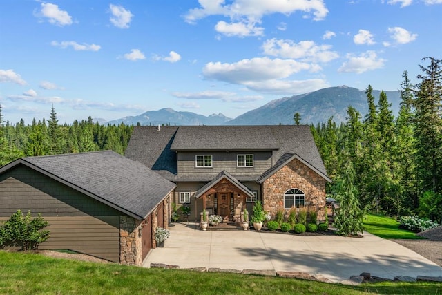 15 Sandi Ln, Heron, MT 59844 - view of front of property featuring stone siding, a mountain view, and concrete driveway