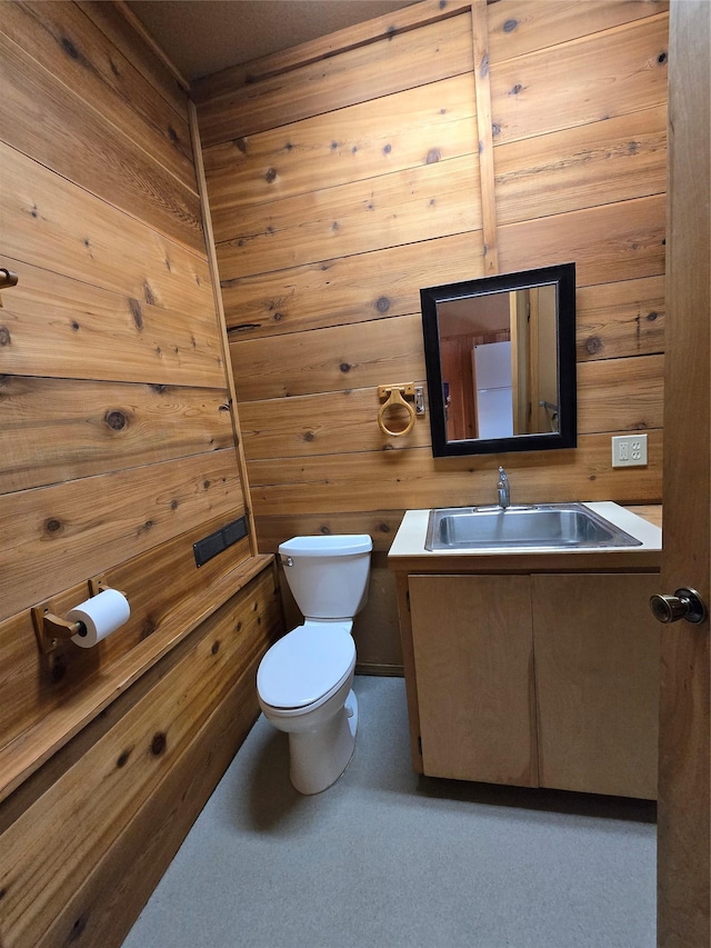 401 Western Larch Ln, Yaak, MT 59935 - half bathroom with vanity, toilet, and wooden walls