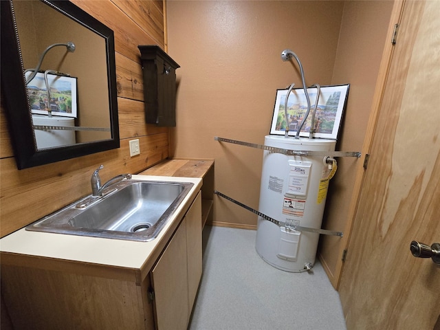 401 Western Larch Ln, Yaak, MT 59935 - laundry area with a sink, secured water heater, wooden walls, baseboards, and carpet floors