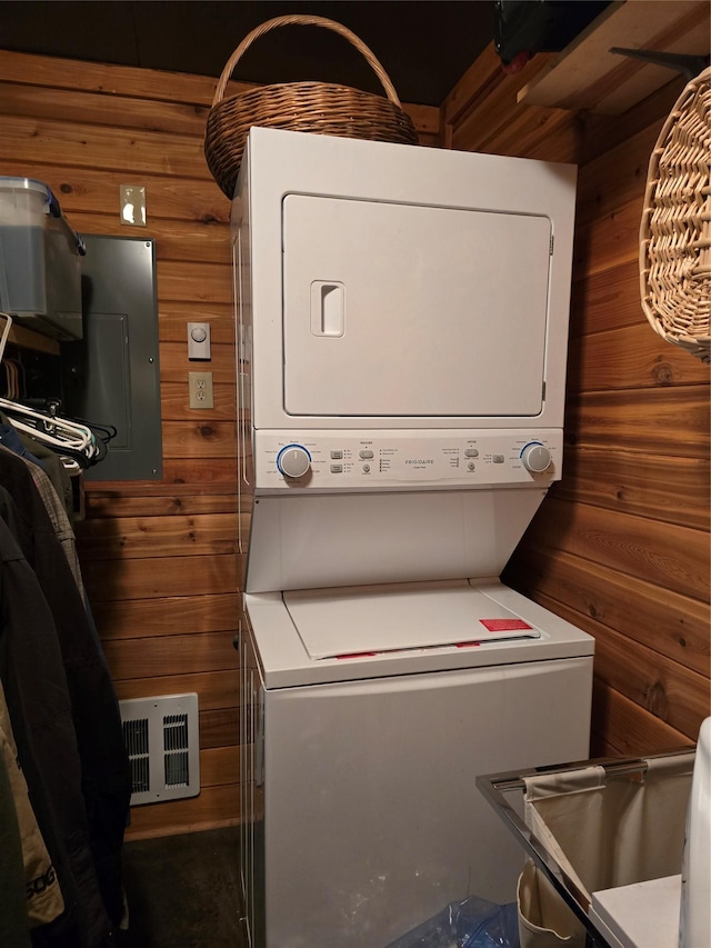 401 Western Larch Ln, Yaak, MT 59935 - laundry area with stacked washer / drying machine, wood walls, and electric panel