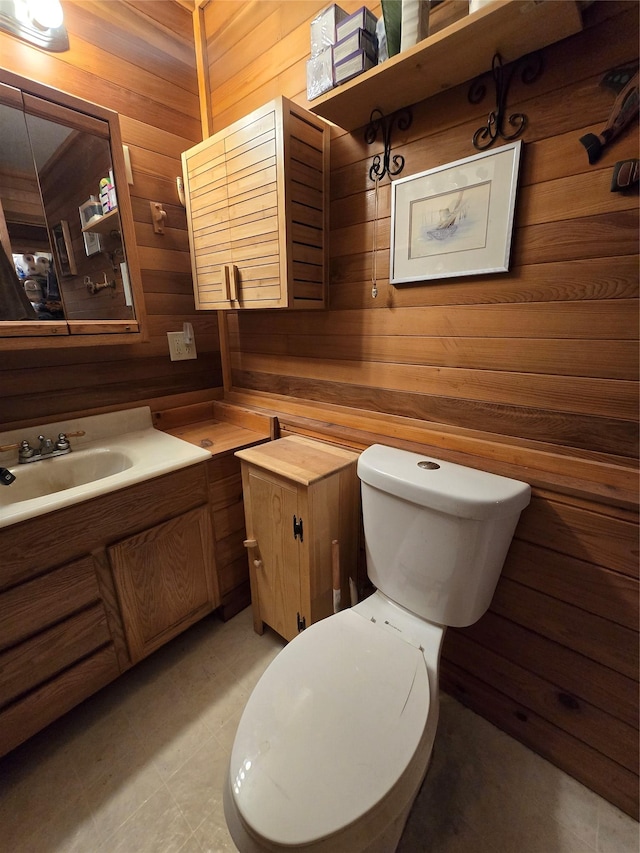 401 Western Larch Ln, Yaak, MT 59935 - bathroom featuring wood walls, vanity, and toilet