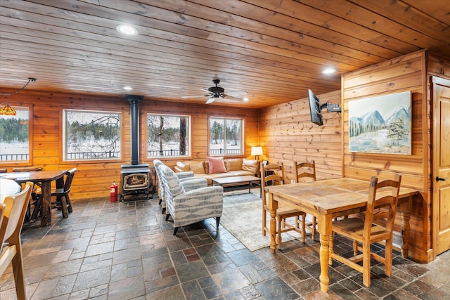 655 Leksand Trl, Whitefish, MT 59937 - dining space with a wood stove, ceiling fan, wood ceiling, wooden walls, and recessed lighting