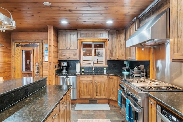 655 Leksand Trl, Whitefish, MT 59937 - kitchen featuring stainless steel appliances, wall chimney range hood, decorative backsplash, stone finish floors, and wood ceiling