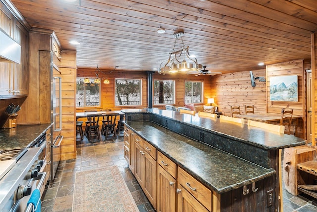 655 Leksand Trl, Whitefish, MT 59937 - kitchen featuring a kitchen island, stone tile floors, wooden walls, wood ceiling, and recessed lighting