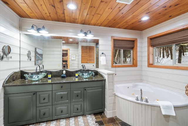 655 Leksand Trl, Whitefish, MT 59937 - bathroom featuring double vanity, ornamental molding, a whirlpool tub, stone finish flooring, and recessed lighting