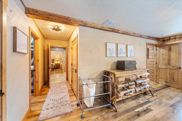655 Leksand Trl, Whitefish, MT 59937 - corridor with light wood finished floors, a textured wall, and a textured ceiling