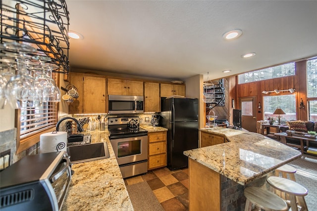 97 Cedar Way Unit 97, Whitefish, MT 59937 - kitchen featuring stainless steel appliances, a sink, recessed lighting, a kitchen bar, and brown cabinetry
