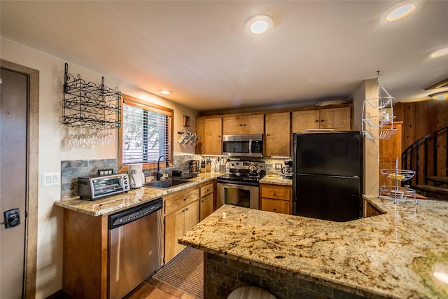 97 Cedar Way Unit 97, Whitefish, MT 59937 - kitchen featuring appliances with stainless steel finishes, a sink, light stone counters, decorative backsplash, and brown cabinets