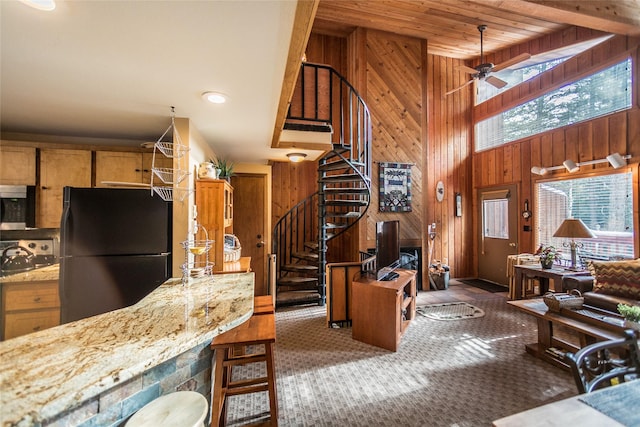 97 Cedar Way Unit 97, Whitefish, MT 59937 - kitchen featuring freestanding refrigerator, plenty of natural light, wooden walls, stainless steel microwave, and a ceiling fan