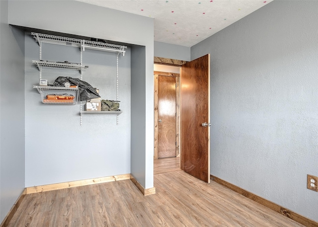 unfurnished bedroom featuring wood finished floors and baseboards