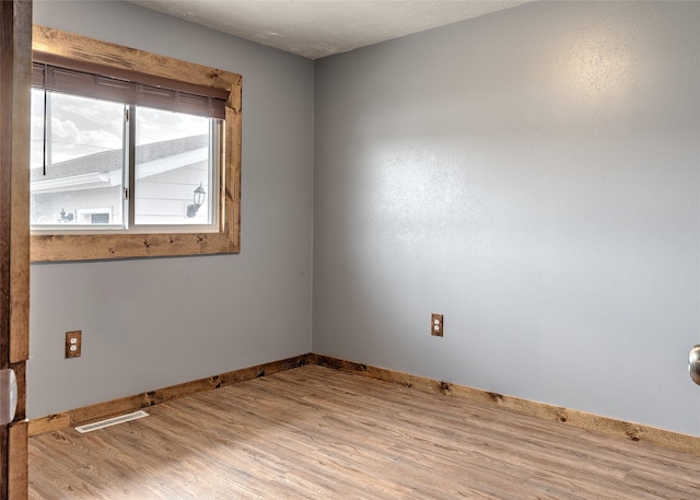 empty room featuring wood finished floors and baseboards