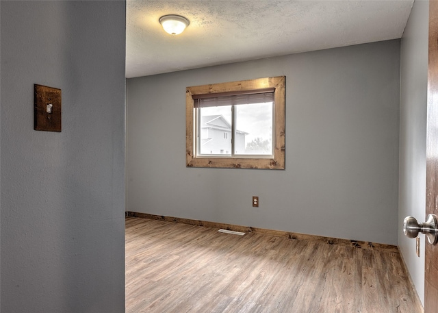 empty room featuring wood finished floors and baseboards