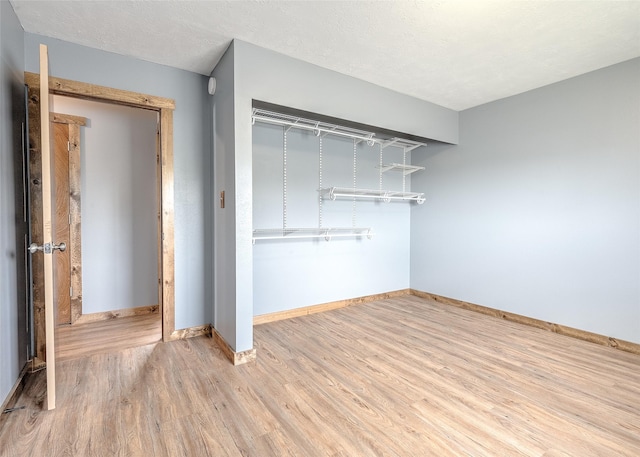 unfurnished bedroom with wood finished floors and baseboards