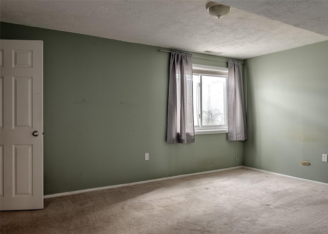 empty room featuring carpet floors, a textured ceiling, and baseboards