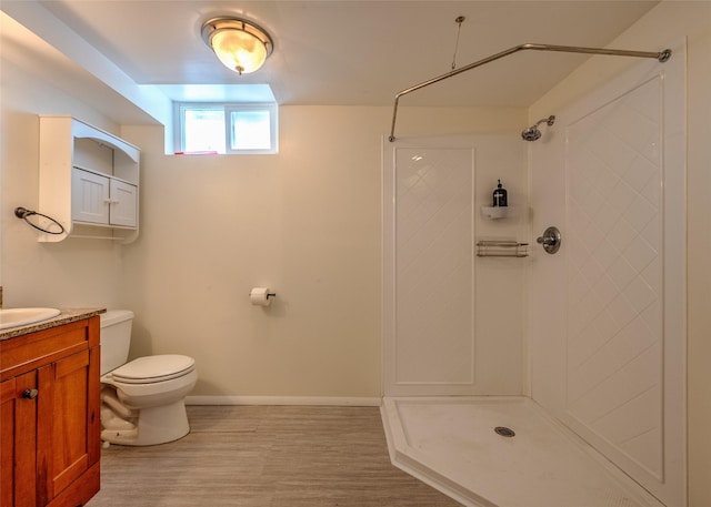 full bath with toilet, a shower, baseboards, vanity, and wood finished floors