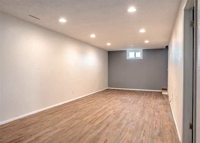 basement featuring recessed lighting, wood finished floors, and baseboards