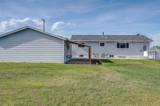 rear view of house featuring cooling unit and a lawn