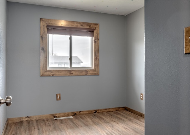 spare room featuring wood finished floors and baseboards