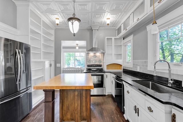 705 N 3rd St W, Missoula, MT 59802 - kitchen featuring stainless steel appliances, wall chimney range hood, a sink, wooden counters, and dark wood-type flooring