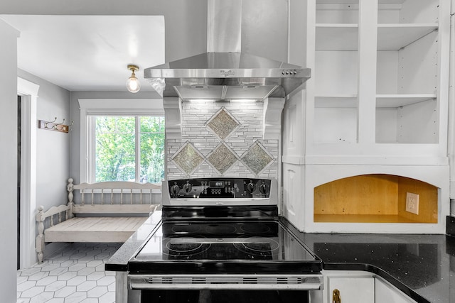 705 N 3rd St W, Missoula, MT 59802 - kitchen featuring stainless steel range with electric cooktop, wall chimney exhaust hood, backsplash, dark countertops, and white cabinetry