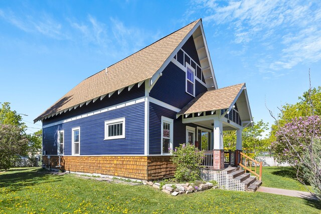 705 N 3rd St W, Missoula, MT 59802 - view of side of property with roof with shingles, covered porch, and a yard